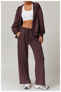 Detailansicht der tiefvioletten Kapuzenjacke und der weit geschnittenen Jogginghose mit hoher Taille