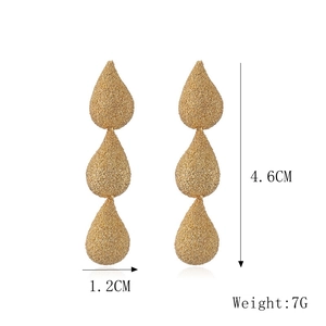 Detail of matte gold teardrop earrings with dimensions 4.6cm length and 7g weight