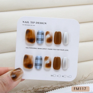 Faux ongles ambrés bruns et à carreaux bleus avec effet œil de chat sur carte blanche