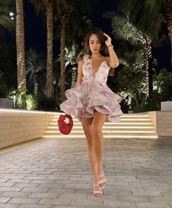 Détail de mini-robe rose sans manches à col en V avec jupon à volants superposés