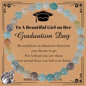 Macro view of natural agate beaded graduation bracelet with ladybug charm on card