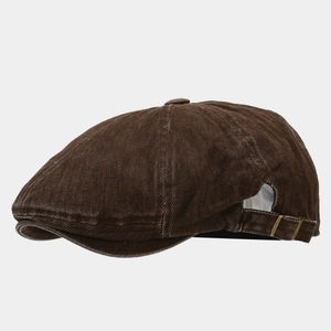 Detail of vintage dark brown flat cap with washed texture and metal side buckle