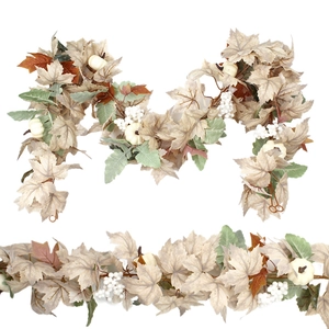 Detail of artificial autumn garland with white pumpkins, maple leaves and berries