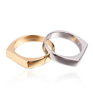 Detail of minimalist flat geometric rings in polished gold and silver titanium steel