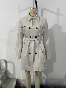 Détail d'un trench-coat beige à boutonnage croisé avec col à revers et ceinture assortie