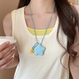 Dettaglio della collana a stella blu con testo a rilievo e piccolo ciondolo a fiore