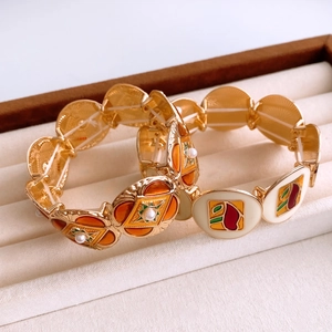 Detail of vintage round bracelets with colorful enamel patterns and white pearls