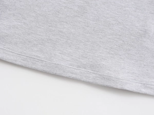 Close-up of light grey knit fabric showing fine texture and double-needle stitching detail