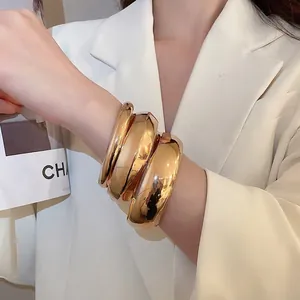 Ensemble de trois bracelets joncs dorés polis avec finition miroir brillante minimaliste