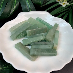 Macro shot of rectangular green quartz stone pendants with drilled holes for DIY jewelry