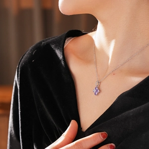 Gros plan du pendentif trèfle à quatre feuilles avec pierres zircons mauves sur chaîne