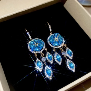 Close-up of blue marquise gemstone dreamcatcher earrings with gold fringe and zircons
