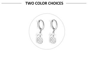 Detailed close-up of pineapple-shaped charms on silver stainless steel hoop earrings