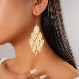Detail of gold-layered leaf tassel earrings showing metallic texture and leaf veins