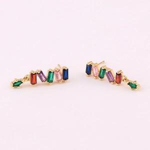 Detail view of gold earrings with rectangular multicolored zircons and green stone pendants