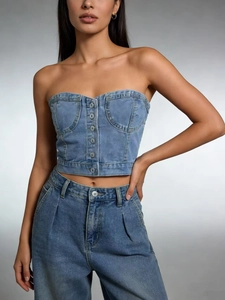 Gros plan du bustier en jean bleu clair montrant la texture du tissu et les boutons