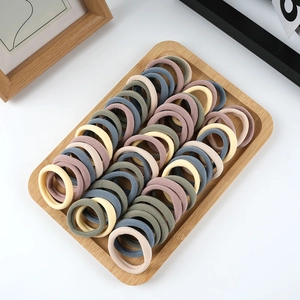 Set of 50 thick seamless hair ties in Morandi colors displayed on a wooden tray