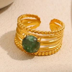 Detailed macro view of multi-layer 18K gold plated ring with a round green gemstone