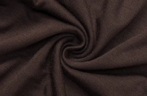 Dettaglio macro della morbida trama a maglia e del filato marrone cioccolato del tessuto
