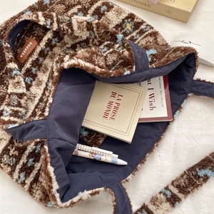 Detail of plush tote bag interior with blue lining showing spacious storage for books
