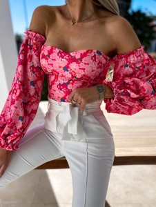Detail of pink floral off-shoulder corset top with lantern sleeves and slim fit