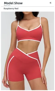 Close-up of raspberry red sports bra and high-waisted shorts with white contrast piping