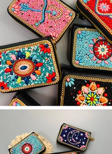 Detailed view of handmade bohemian beaded card purses with colorful patterns and gold zippers
