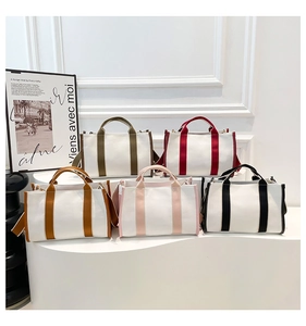 Canvas tote bags in five colors displayed on white steps for stylish commuting