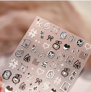 Macro detail of silver embossed nail stickers with Roman numerals and butterflies