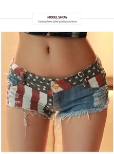 Dettaglio di pantaloncini di denim sfrangiati con stampa bandiera USA ed effetto usurato