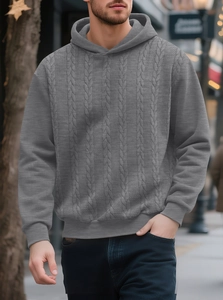 Detailed view of men's grey cable knit hoodie showing thick texture and ribbed cuffs