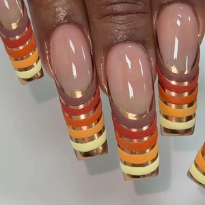 Detailed macro view of long square nails with four-color stripes and gold wire accents