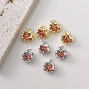 Close-up of 14K gold-plated pomegranate pendants with red zircon for jewelry making