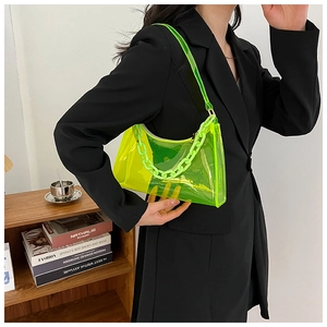 Neon green transparent jelly shoulder bag with matching thick chain shown on model in suit