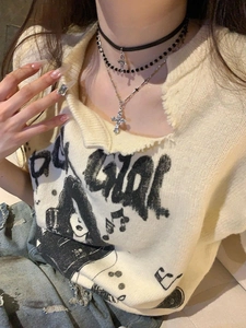 Detail shot of a layered black leather choker and crystal cross pendant necklace
