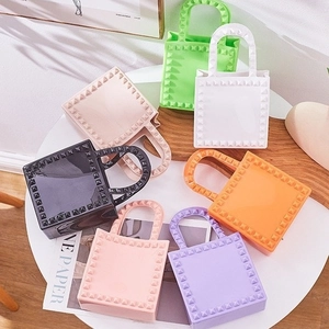 Colorful PVC jelly handbags with rivet accents arranged on a white table in seven colors