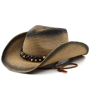 Détail d'un chapeau de paille de style western avec dégradé et ruban de perles ethniques