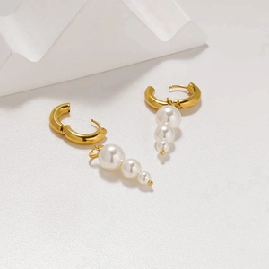 Pendientes de aro franceses bañados en oro 18K con tres perlas blancas degradadas en fondo blanco