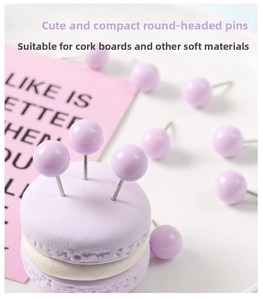 Close-up of purple push pins with plastic heads on macaron prop and pink background
