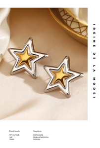 Macro shot of two-tone star earrings with silver and gold finish on champagne silk