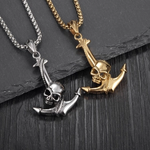Gothische Totenkopf und Anker Anhänger in Silber und Gold auf dunklem Schieferhintergrund