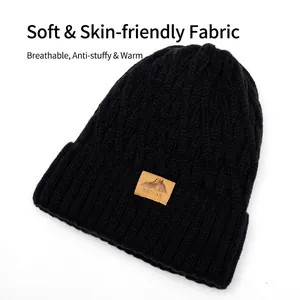 Men's black cable knit winter beanie with warm fleece lining and mountain leather patch