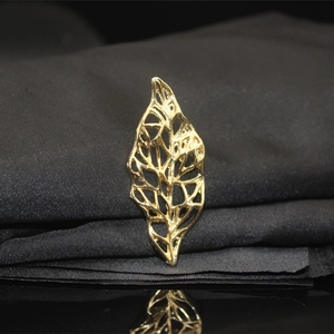 Macro shot of golden hollowed leaf design with intricate vein texture and metallic shine