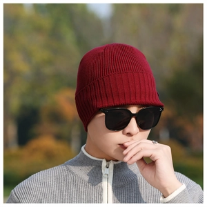 Detailed knit texture and ribbed pattern of the burgundy winter beanie worn by a model