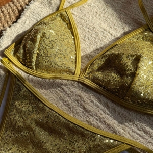 Close-up of golden sequins on a halter bikini set with shiny metallic texture detail