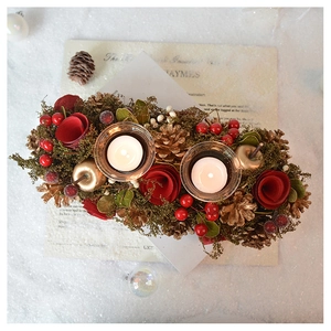 Detail of vintage double candle holder with red roses, pine cones and berries on snow
