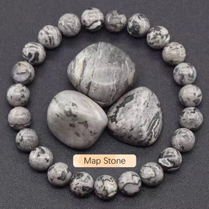 Macro shot of natural grey map stone beaded bracelet and polished raw stones with labels