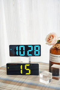 Close-up of dual LED digital clocks showing blue time and yellow temperature in Celsius