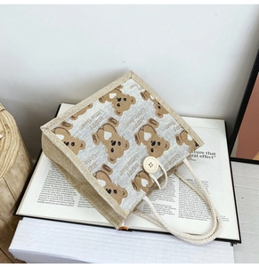 Close-up of linen bear lunch bag with cotton rope handles and wooden button closure