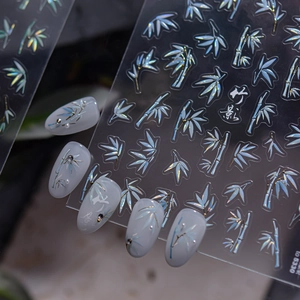 Macro shot of 3D aurora bamboo leaf nail stickers with elegant gold outlines and 3D texture